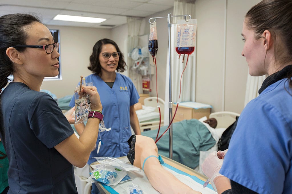 PLU nursing students in sim lab working with lab equipment