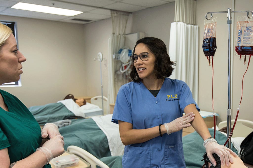 PLU nursing students talking in simulation lab