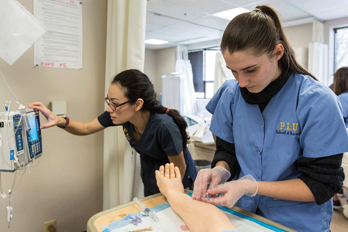 PLU nursing students in sim lab working with lab equipment