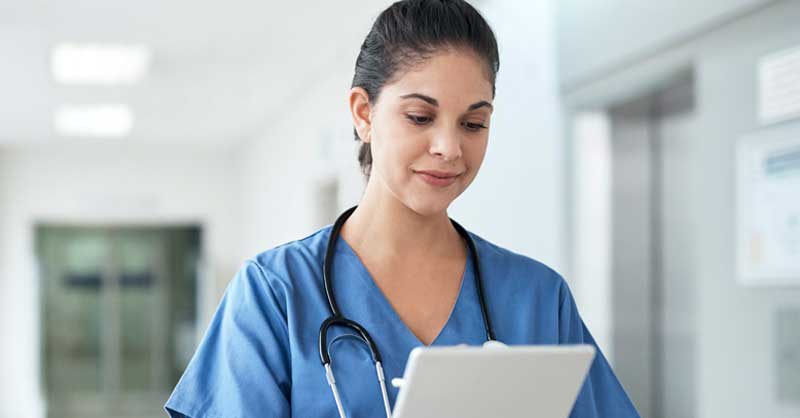 Nurse looking down at clipboard