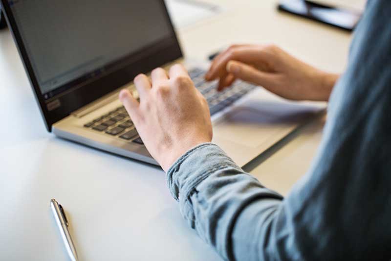 closeup of a person typing on a laptop