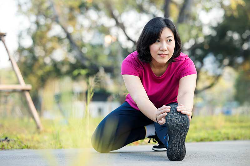 woman outside stretching her legs before a run