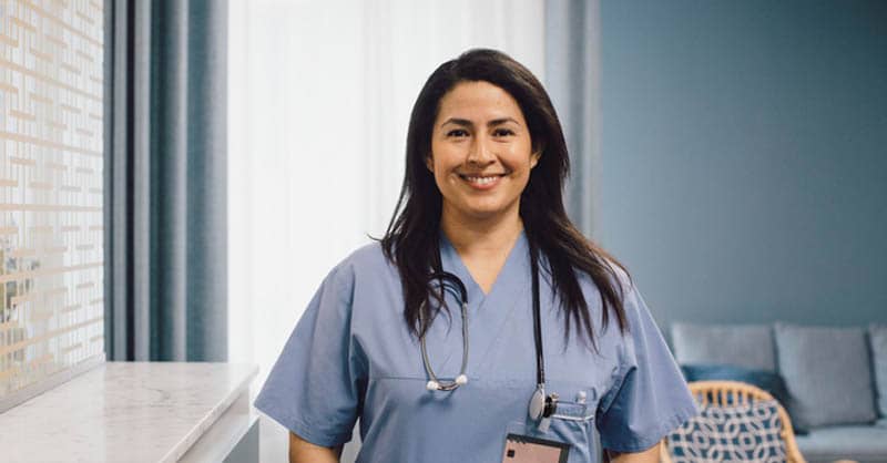 nurse standing and smiling in room