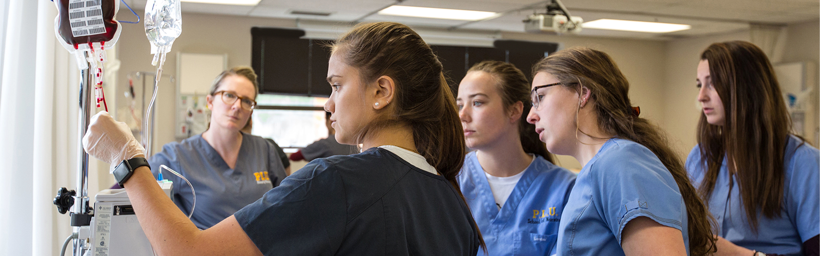 PLU ABSN students looking at IV in simulation lab