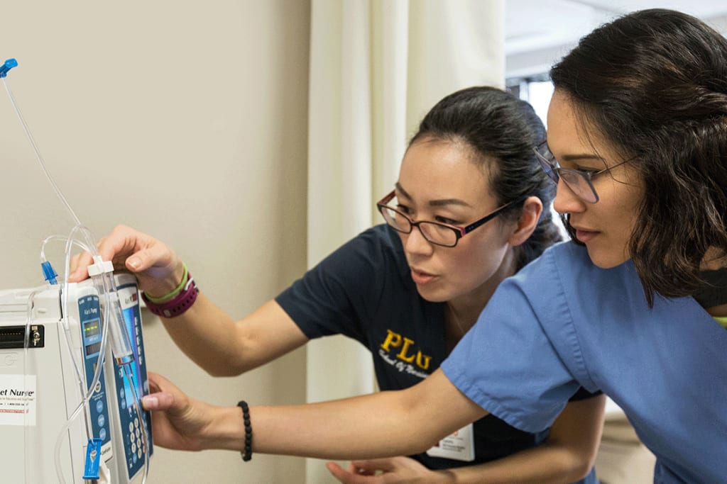 PLU nursing students looking at lab equipment