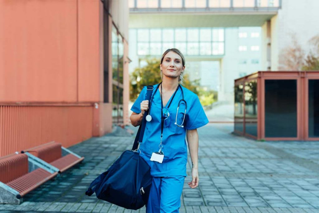 EMT nurse carrying bag outside