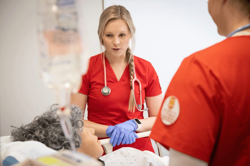 UST nursing students working in sim lab