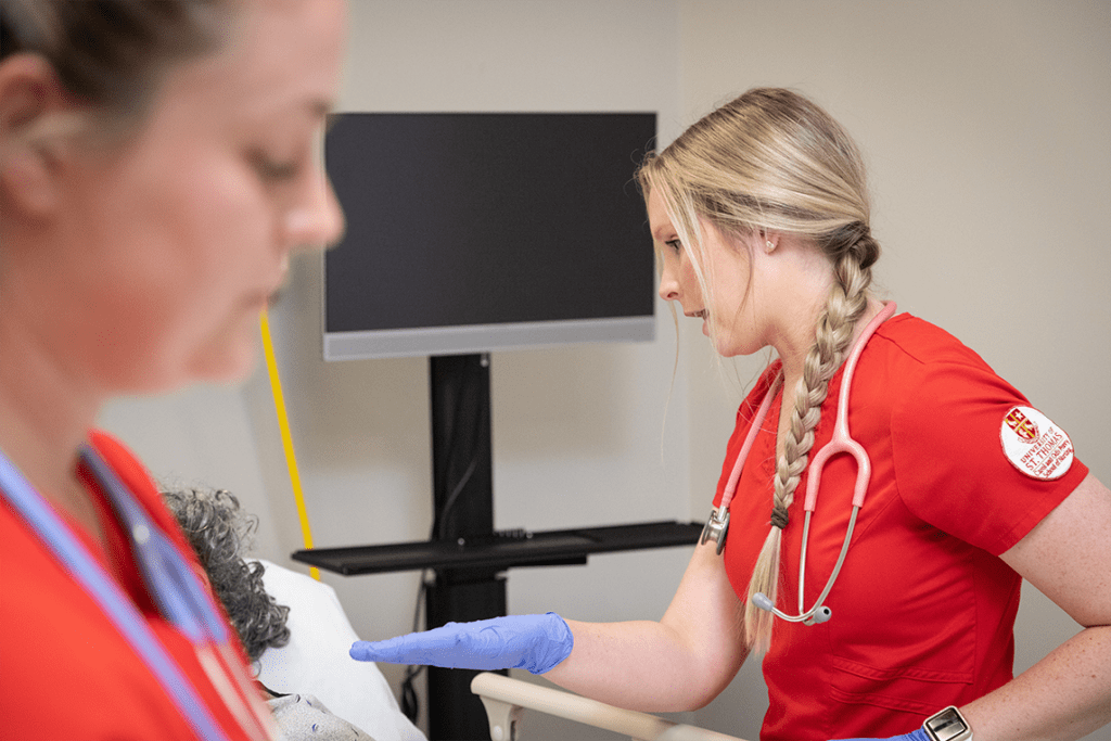 two UST ABSN students working in sim lab