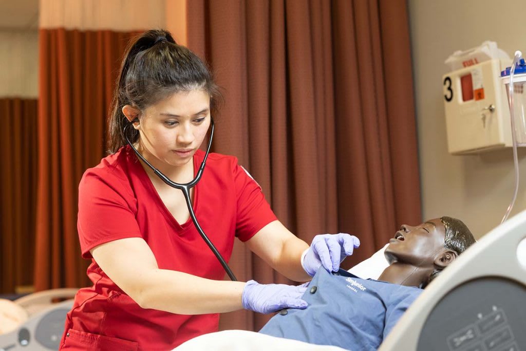 nurse listening to patients heartbeat