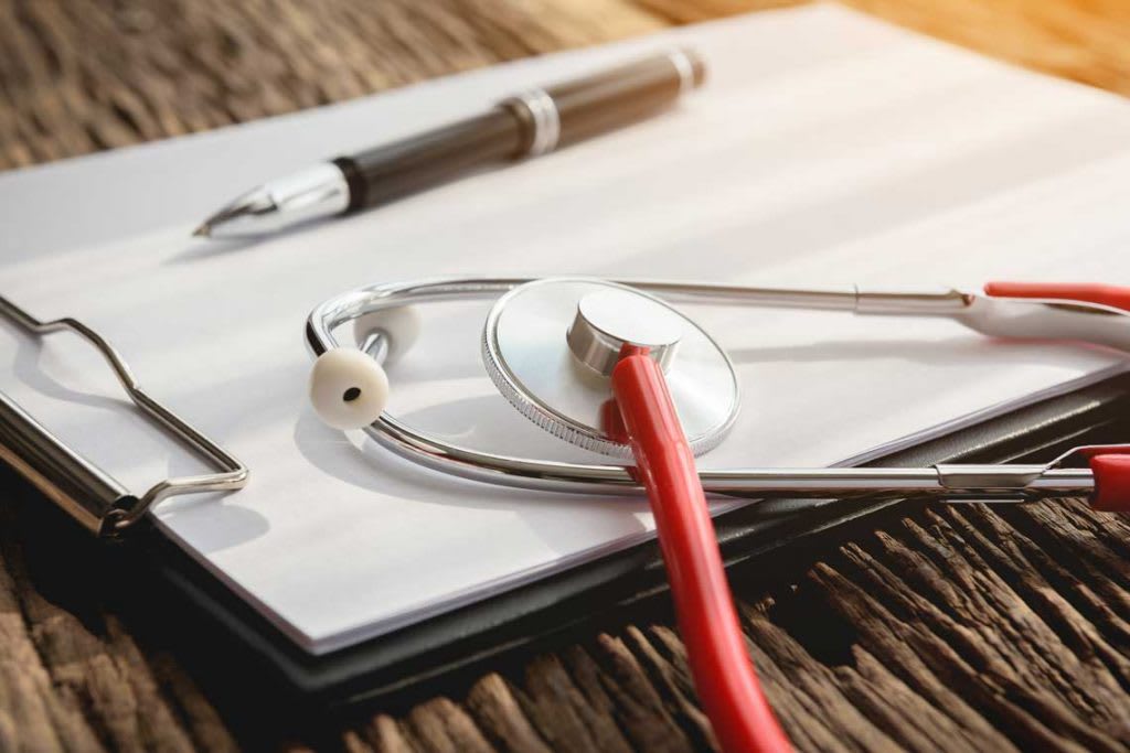 red stethoscope on clipboard with pen