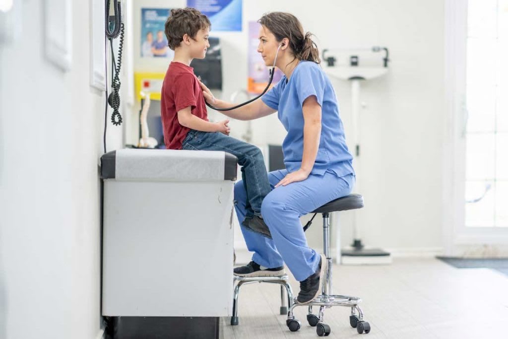 nurse listening to child patient's heartbeat