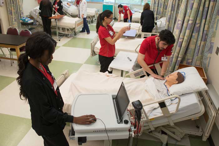 several student actively participating in a nursing simulation lab