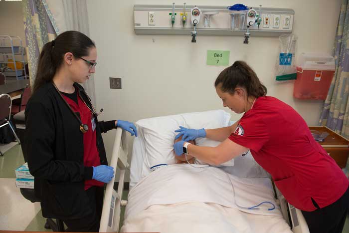 two UIW nursing students with a simulation manikin