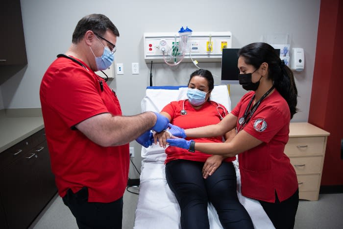 3 nursing students practicing skills in a clinical setting