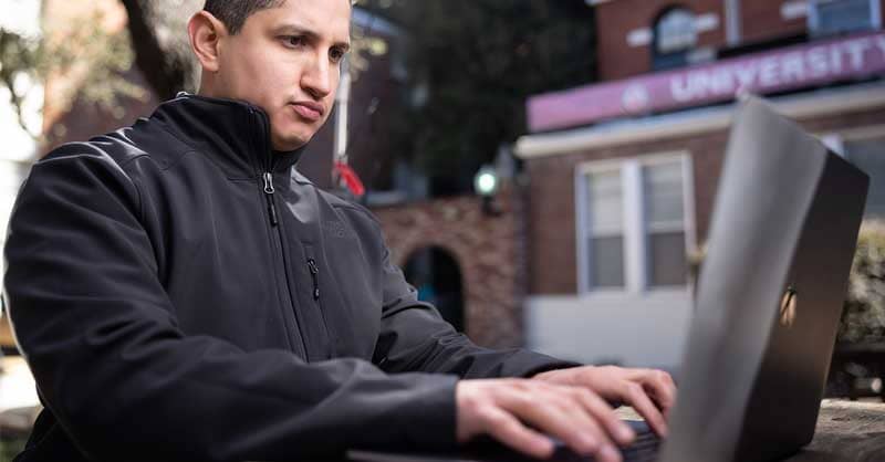 Man sitting at table using laptop