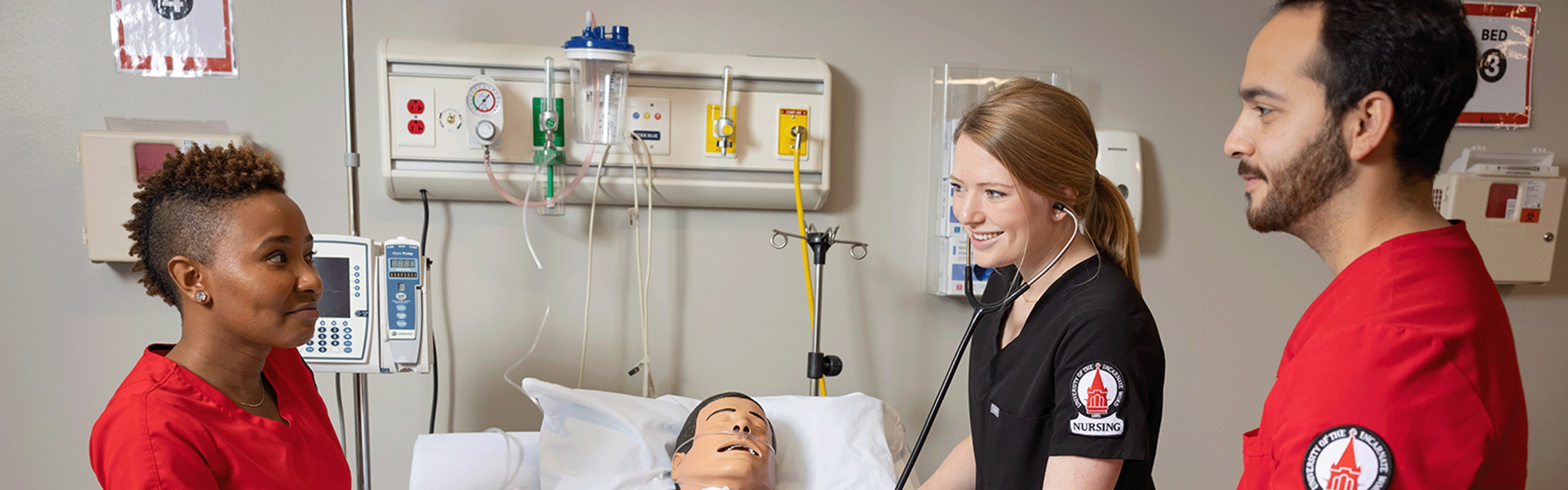 nursing students in clinical setting around manikin