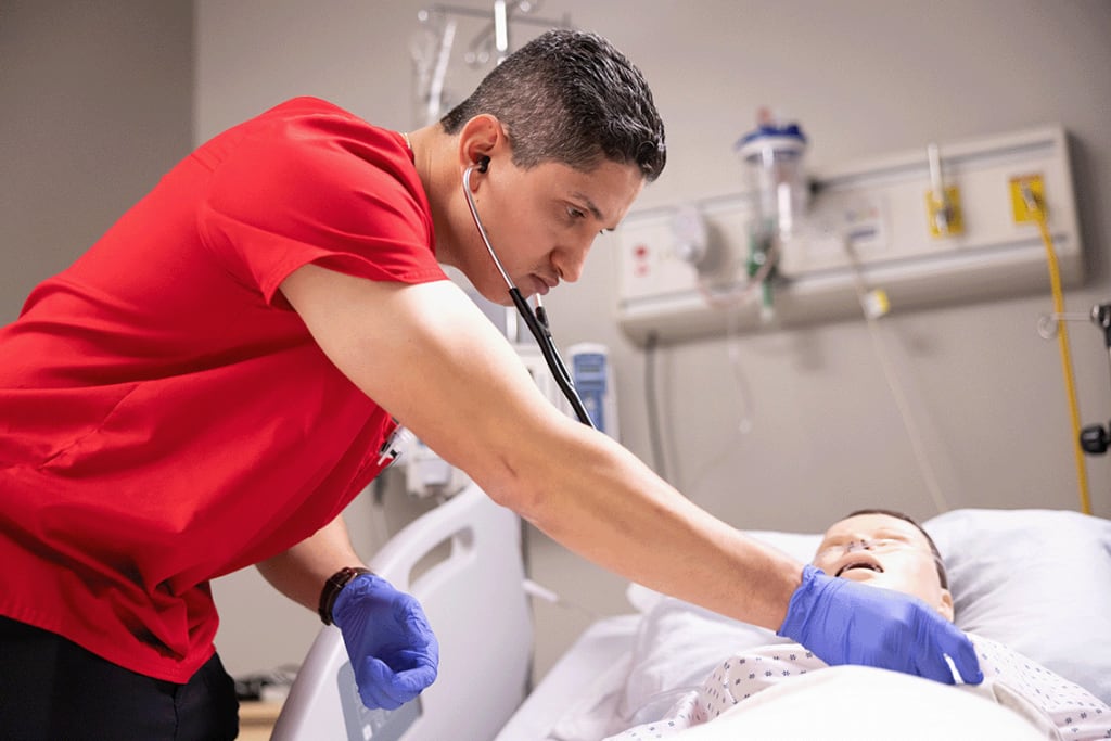 UIW practicing on manikin with stethoscope