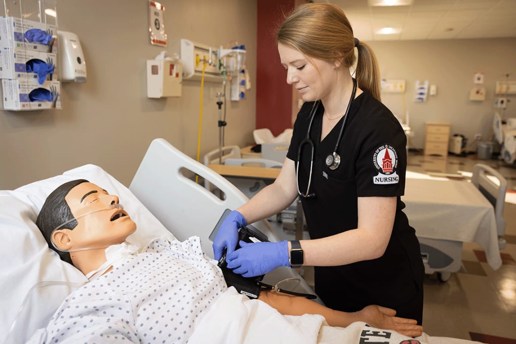 UIW nursing student in lab setting working on a manikin