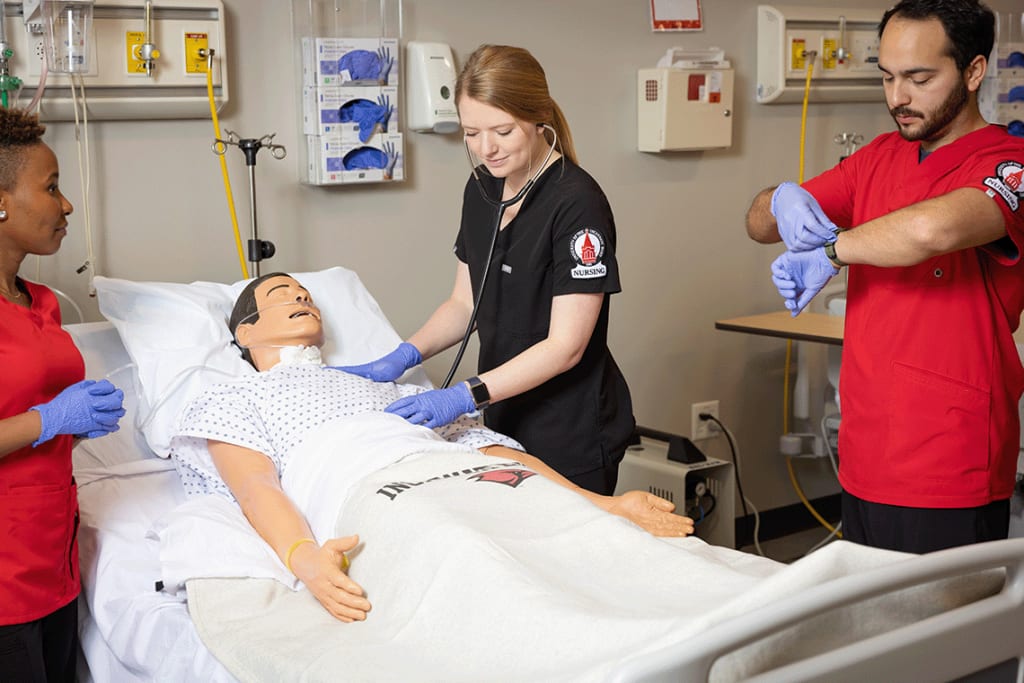 3 UIW nursing students in lab setting working on a manikin