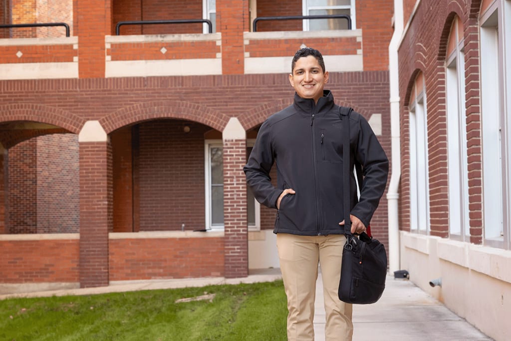 Nursing student standing outside in front of UIW campus buildings