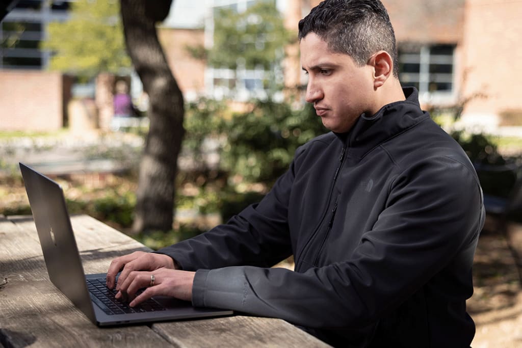 Nursing student sitting outside with computer