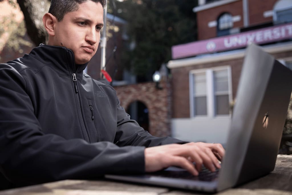 UIW student typing on laptop