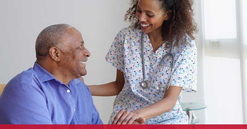 nurse helping older patient in chair