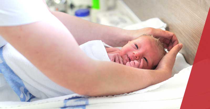 close up of a nurse's hands washing a baby's head