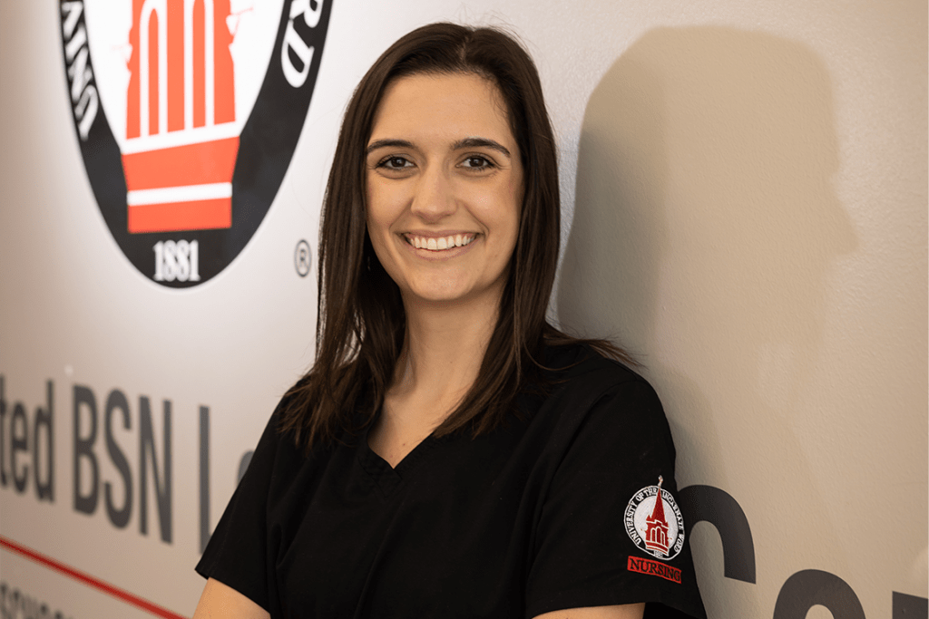 UIW nursing student smiling leaning up against the wall