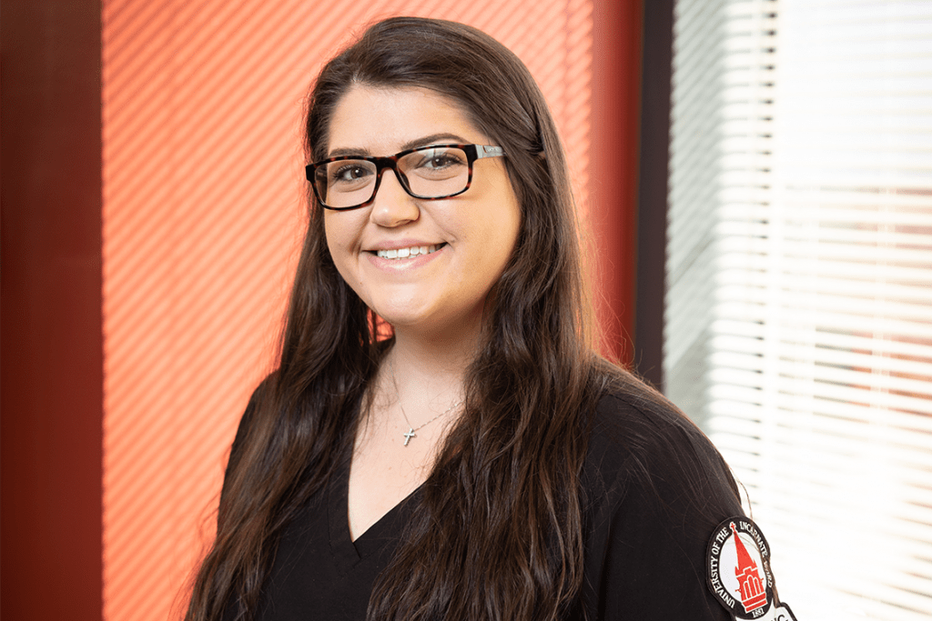 UIW nursing student in glasses posing in front of window