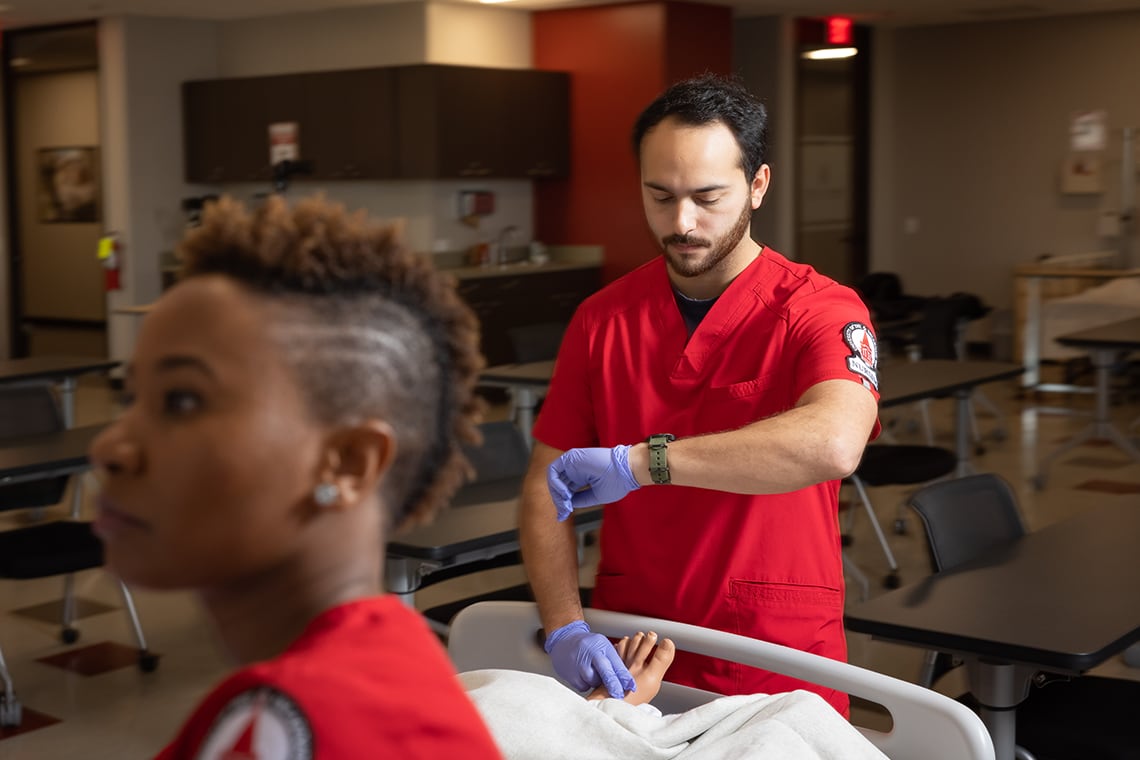 UIW nursing student checking his watch in a clinical setting