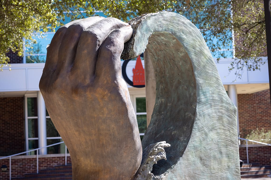 Hand and rock on UIW's campus coming together to form a heart sculpture