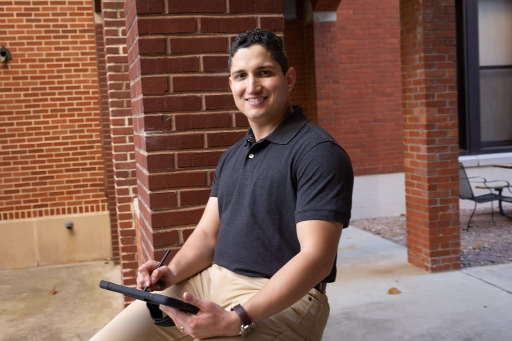 man sitting down using digital tablet