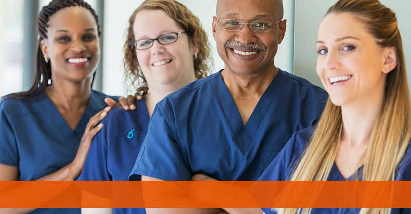 four nurses standing together smiling