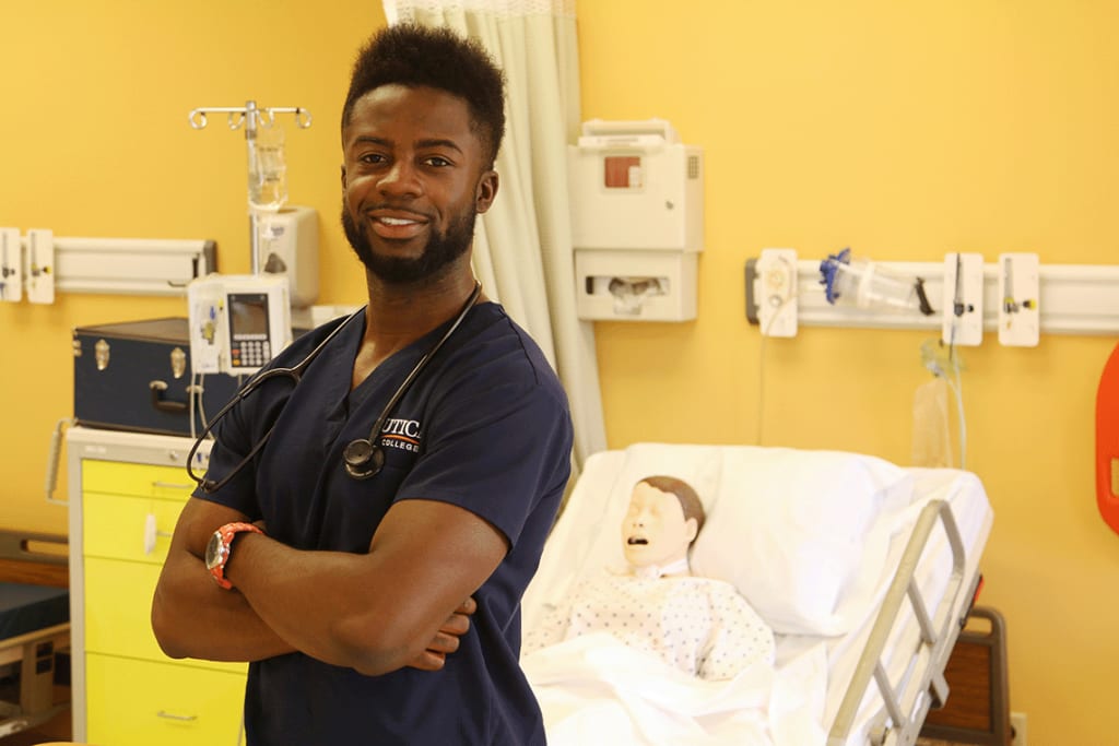 Utica student smiling while in a clinical setting