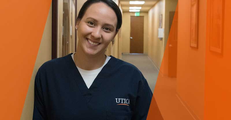 Utica ABSN student standing in hallway smiling