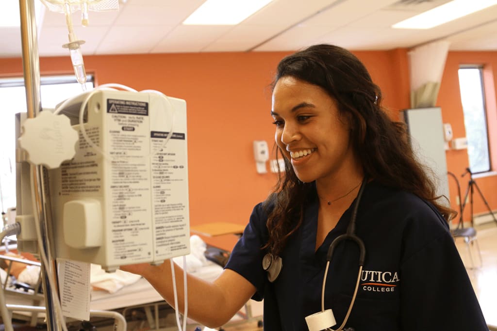 Utica student smiling in a clinical setting