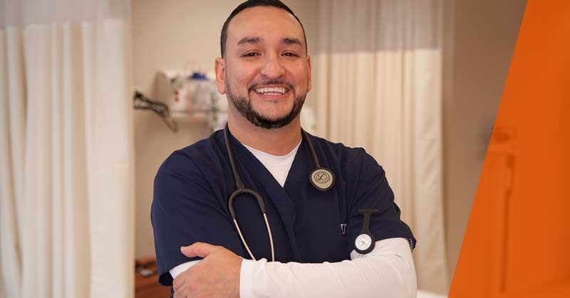 Utica ABSN student standing in blue scrubs smiling