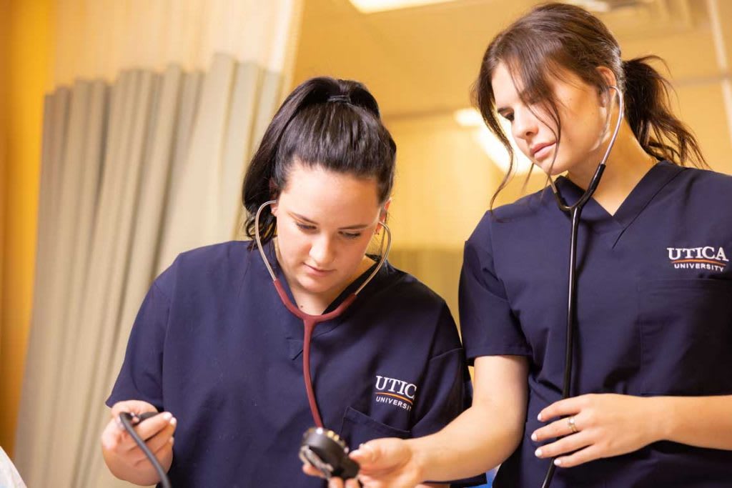 two Utica nursing students working in lab