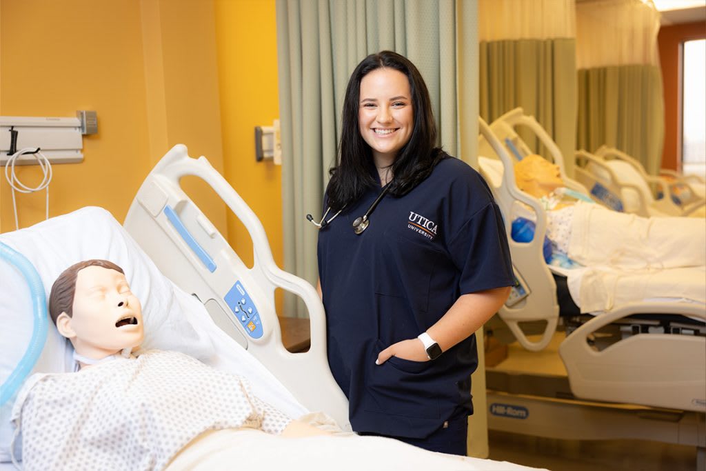 utica nursing student next to manikin