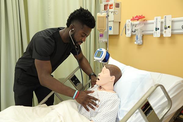 Nursing student works with manikin