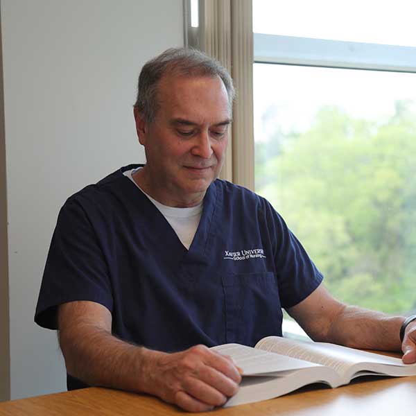 Xavier ABSN graduate Greg reading a book