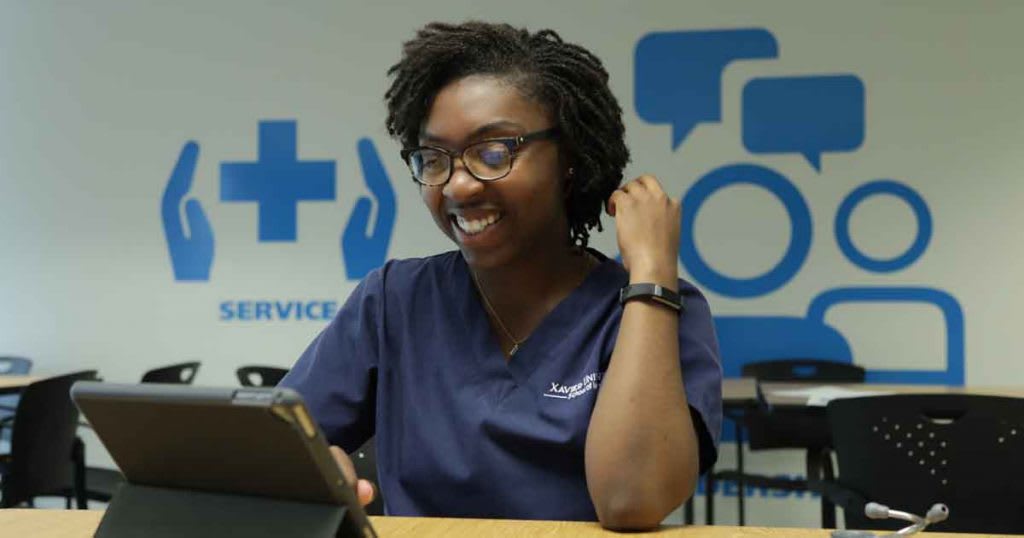 nursing student sitting at table using tablet
