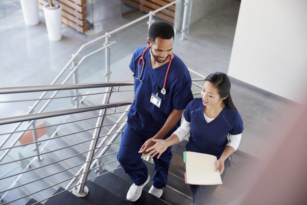 Two nurses walking up stairs talking