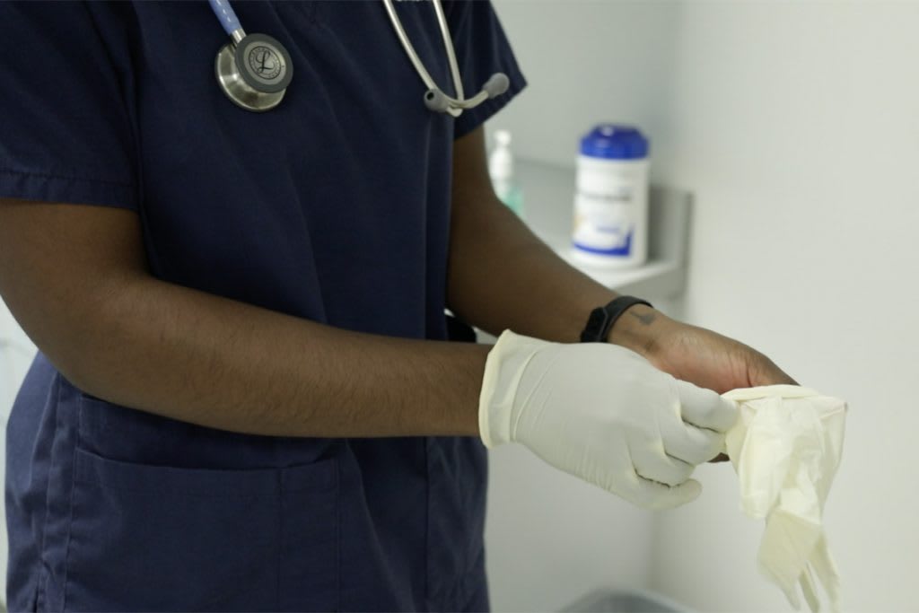 close up of xavier student putting on gloves