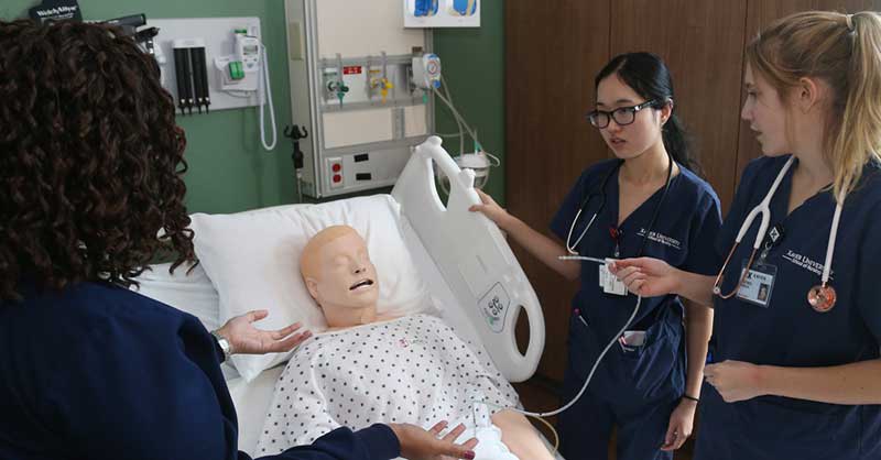 nursing students in clinical setting with manikin