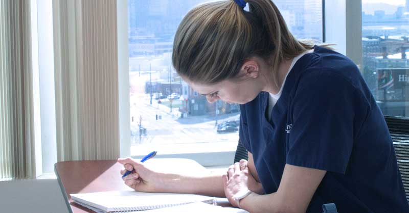 Student studying and writing in notebook