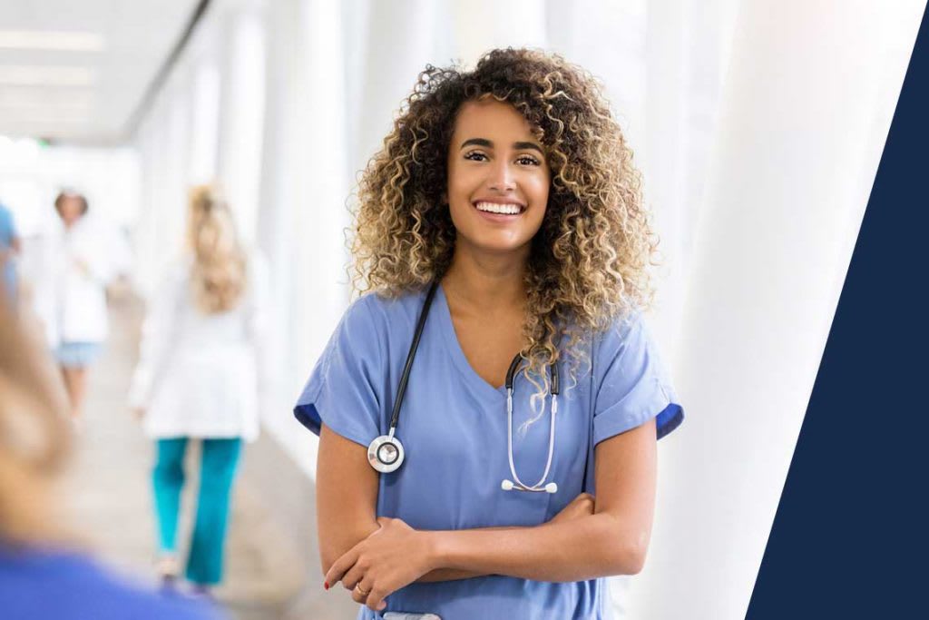 smiling nurse standing in a hallway