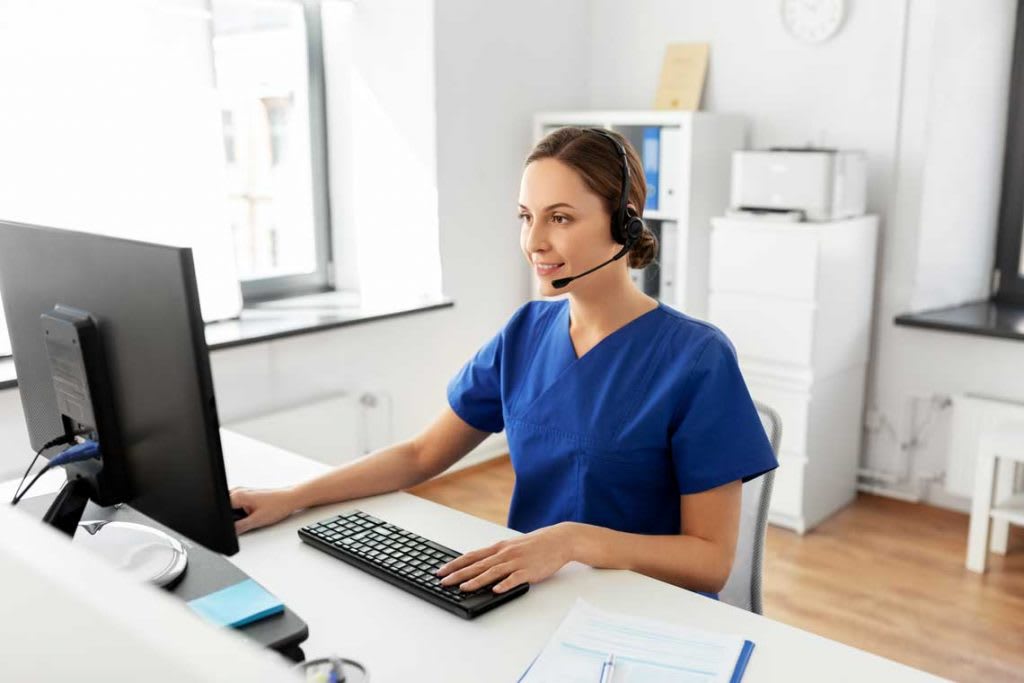 nurse sitting at desk with headset