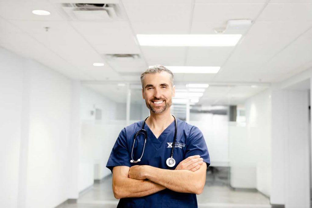 Xavier ABSN student standing in hallway smiling